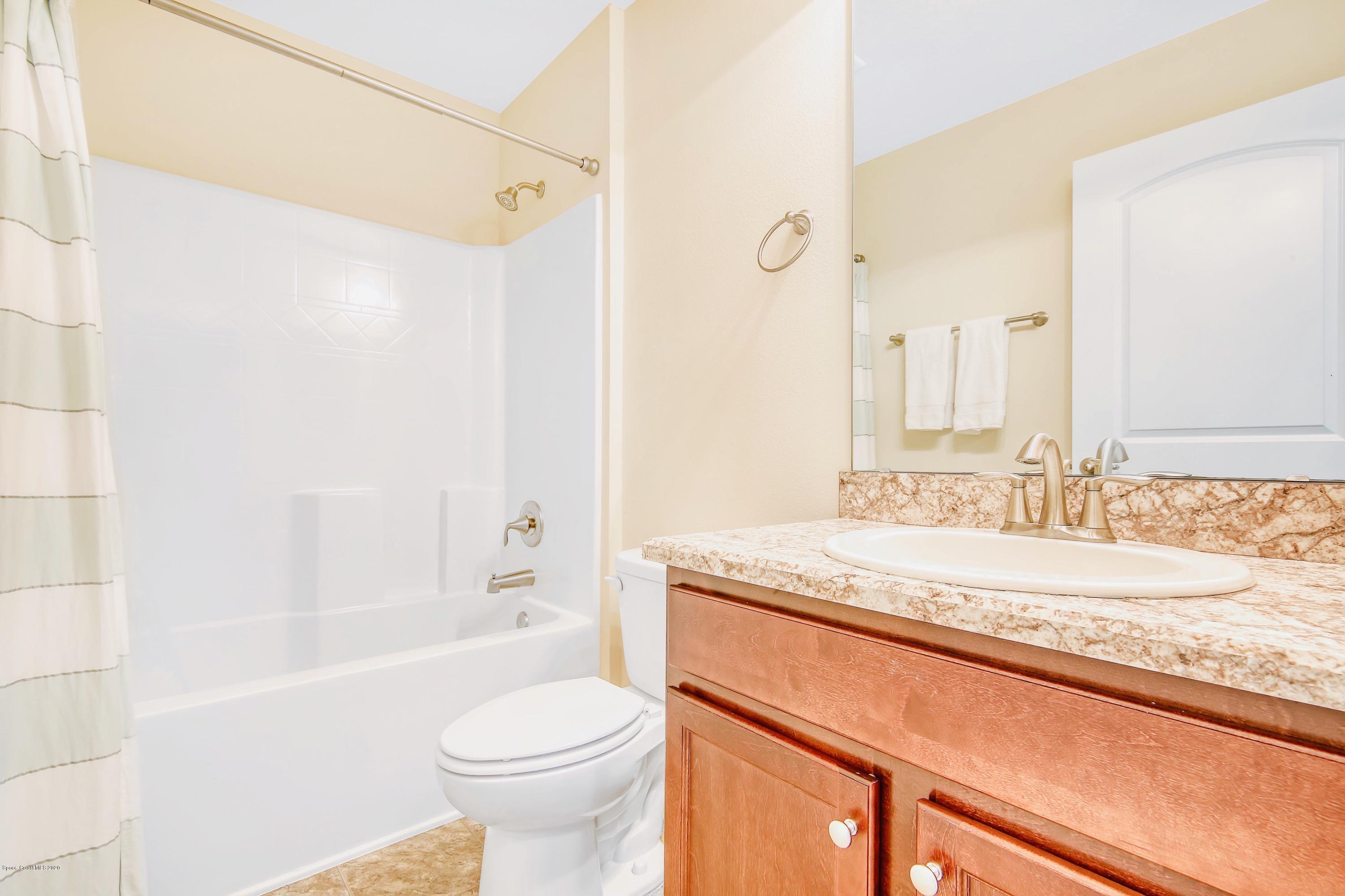 919 Thompson Road Southwest Palm Bay, FL 32908 - Photo 25 of 38 a bathroom with a granite countertop sink toilet and shower