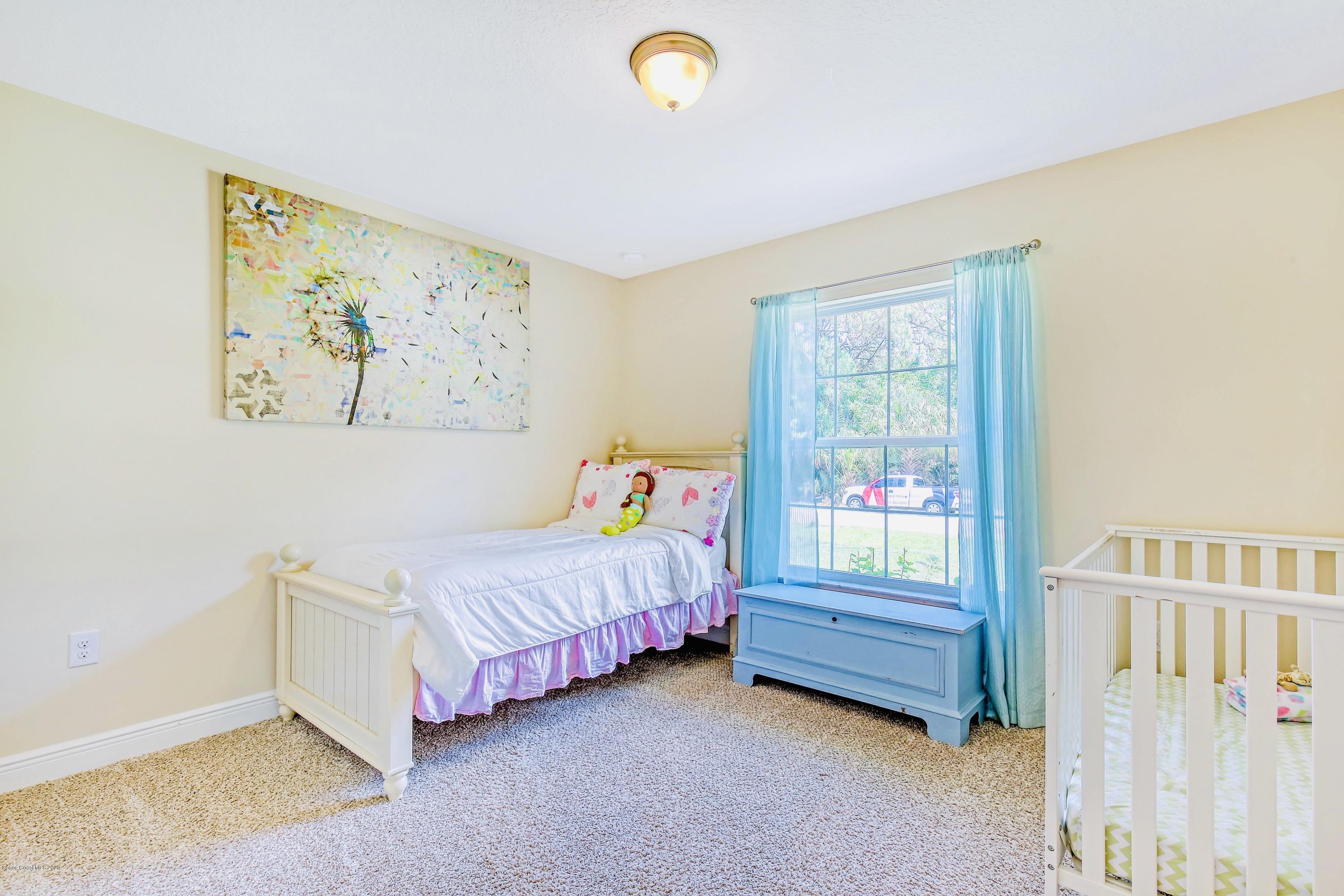 919 Thompson Road Southwest Palm Bay, FL 32908 - Photo 26 of 38 a bedroom with a bed and a window