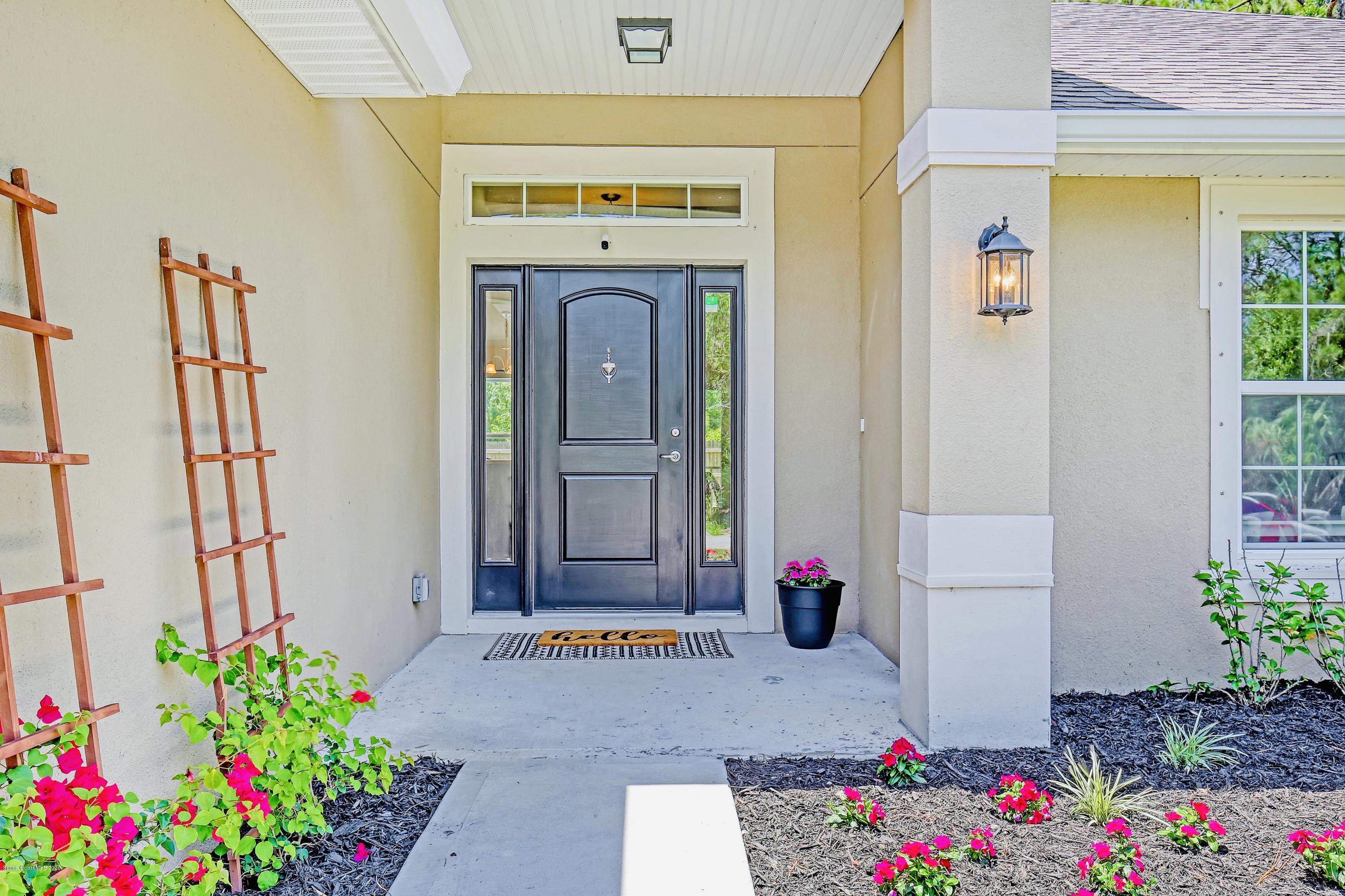 919 Thompson Road Southwest Palm Bay, FL 32908 - Photo 4 of 38 a front view of house with flowers