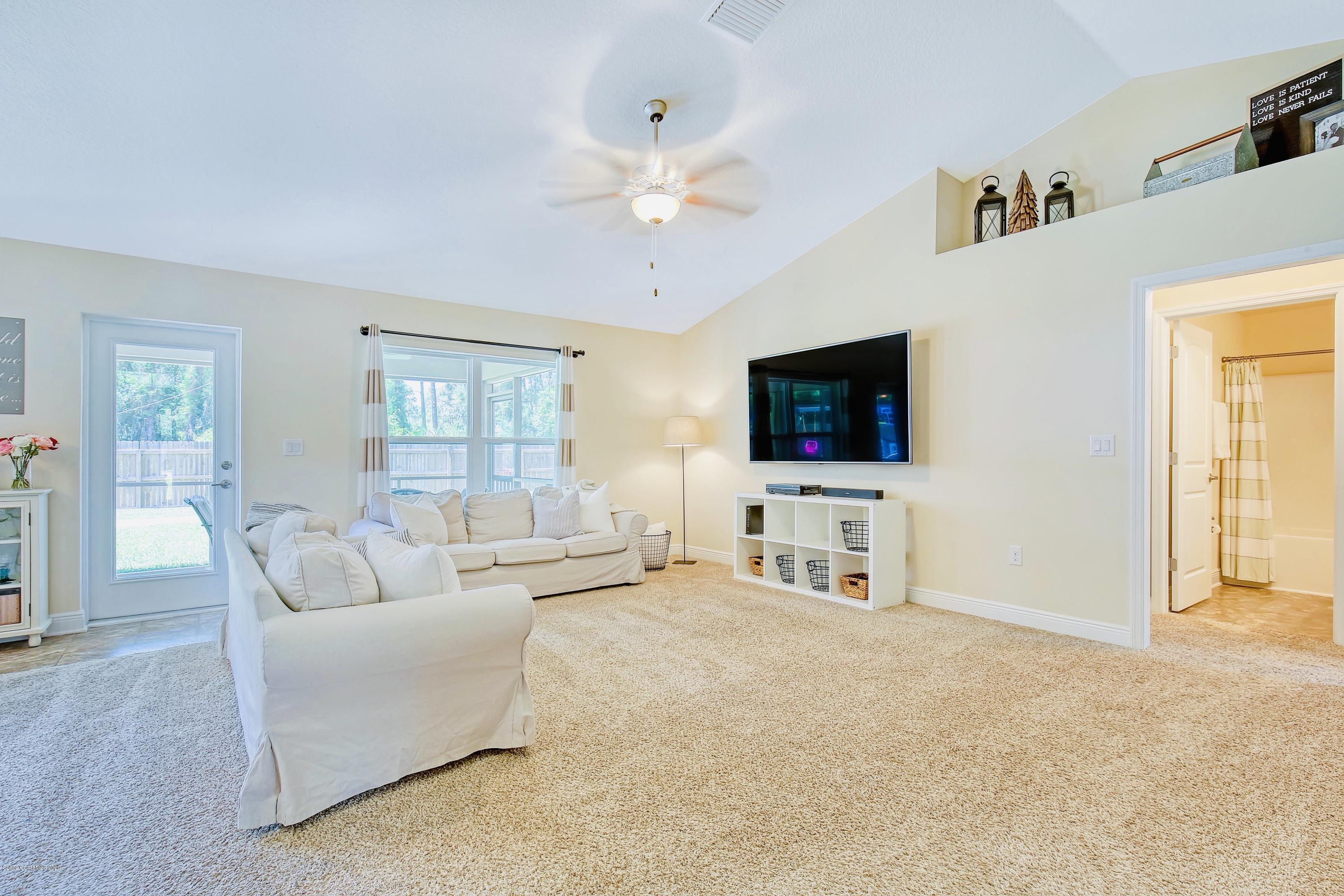 919 Thompson Road Southwest Palm Bay, FL 32908 - Photo 6 of 38 a living room with furniture and a flat screen tv