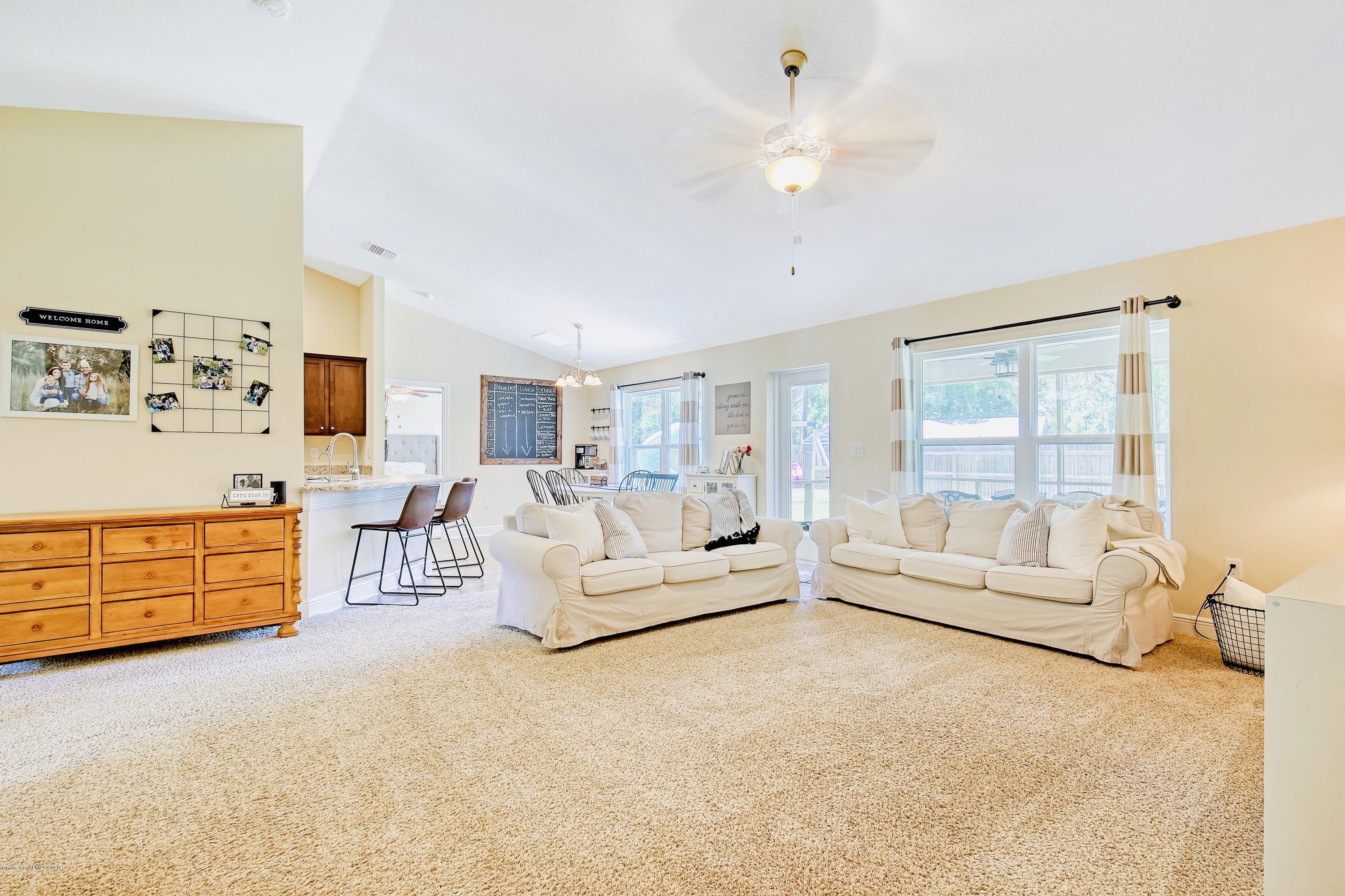 919 Thompson Road Southwest Palm Bay, FL 32908 - Photo 7 of 38 a living room with furniture and a flat screen tv