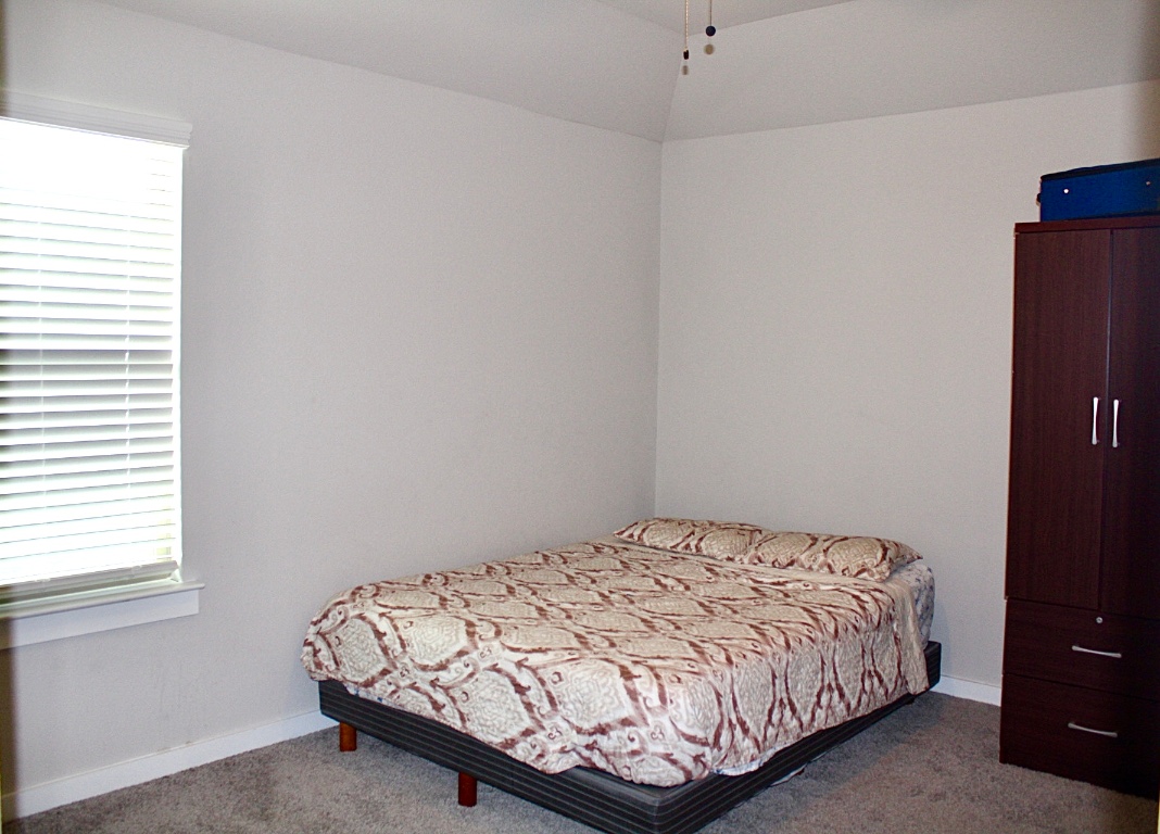 174 Gullivers Drive Elgin, TX 78621 - Photo 13 of 28 a bed sitting in a bedroom next to a window