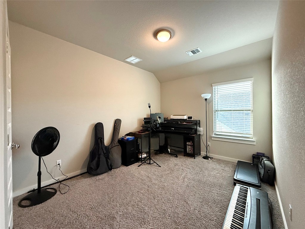 174 Gullivers Drive Elgin, TX 78621 - Photo 18 of 28 a view of a workspace with furniture and a window
