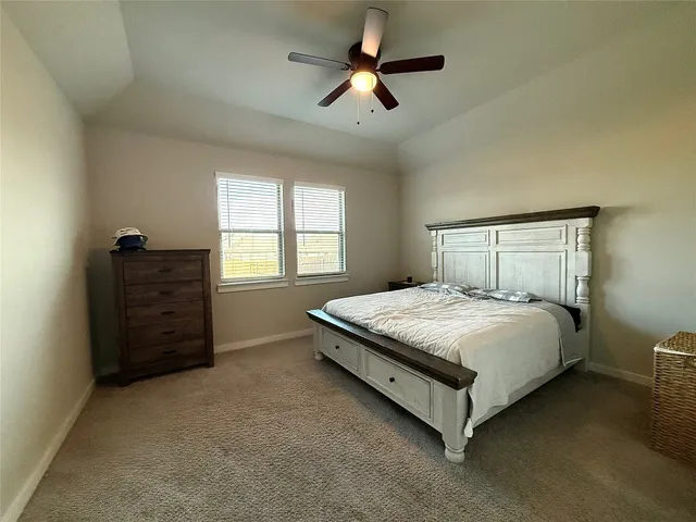 a bedroom with a bed and a ceiling fan