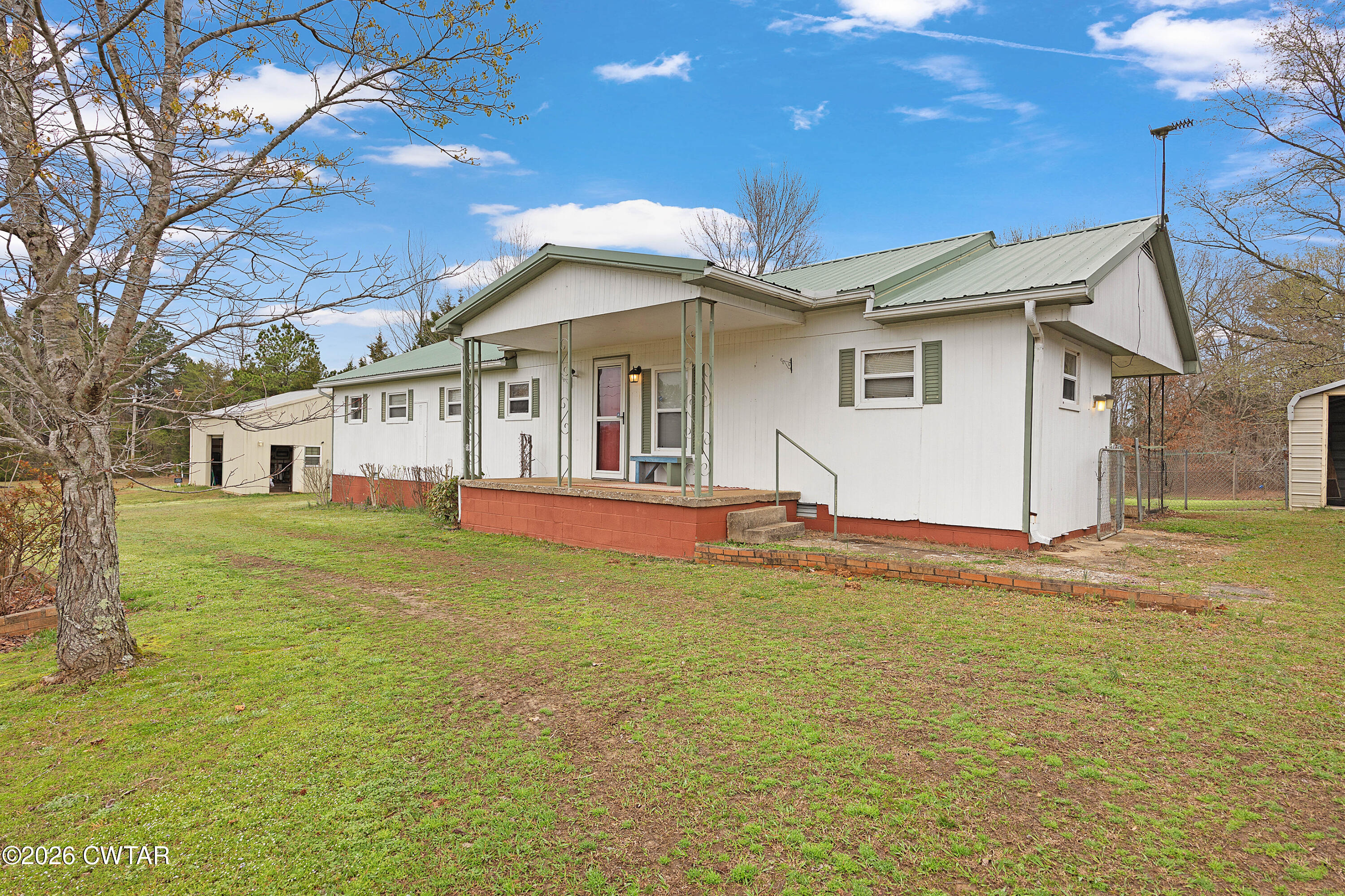 65 Aldridge Lane Jackson, TN 38305 - Photo 3 of 14 a view of a white house with a big yard and large trees