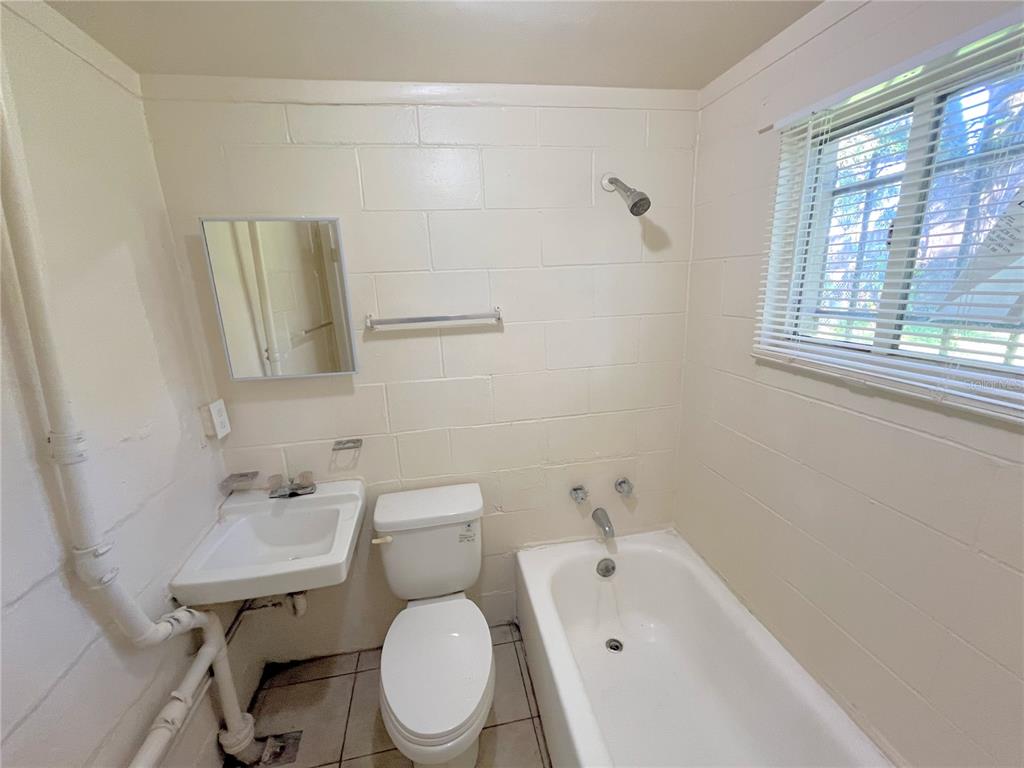 1235 Cypress Street, Unit 1/2 Orlando, FL 32805 - Photo 12 of 19 a white toilet sitting next to a bathroom sink