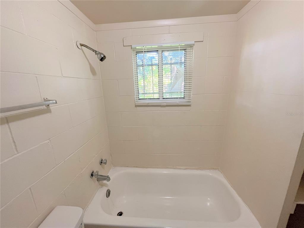 1235 Cypress Street, Unit 1/2 Orlando, FL 32805 - Photo 13 of 19 a bathroom with a bathtub and window