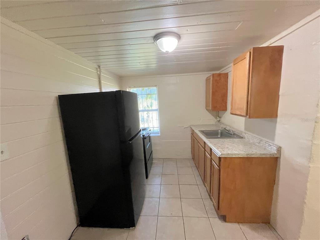 1235 Cypress Street, Unit 1/2 Orlando, FL 32805 - Photo 5 of 19 a kitchen with a refrigerator and a sink