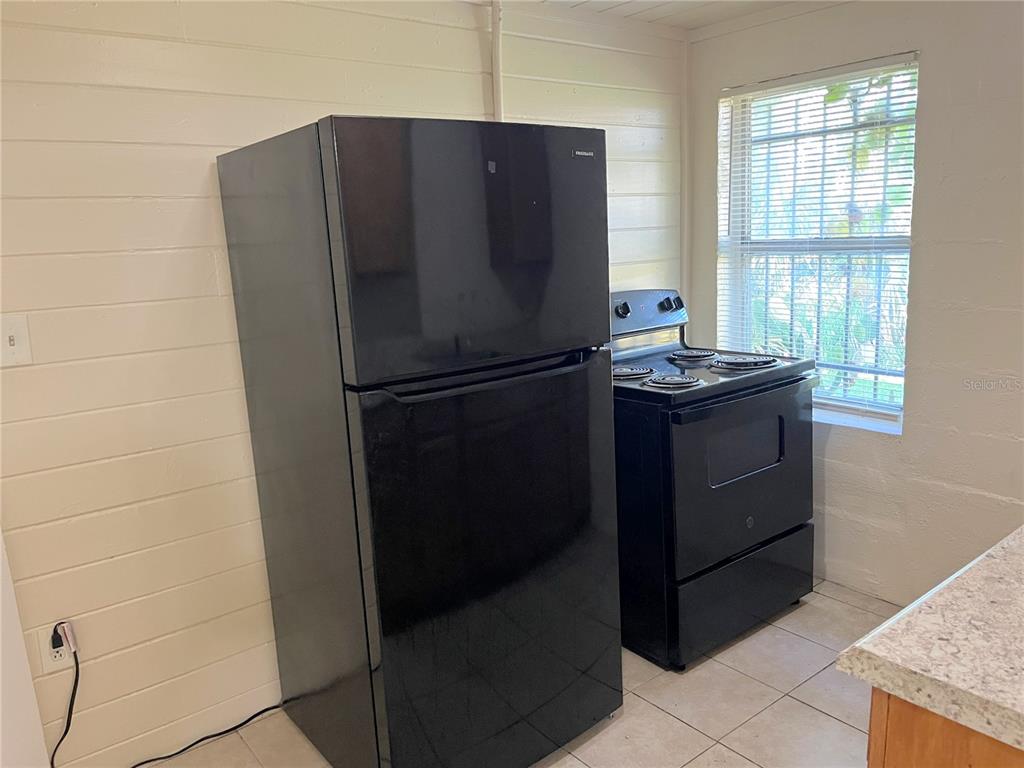 1235 Cypress Street, Unit 1/2 Orlando, FL 32805 - Photo 6 of 19 a white refrigerator freezer sitting in a kitchen