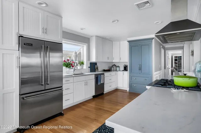 a kitchen with a refrigerator sink and cabinets