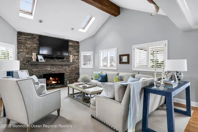 a living room with furniture a flat screen tv and a fireplace