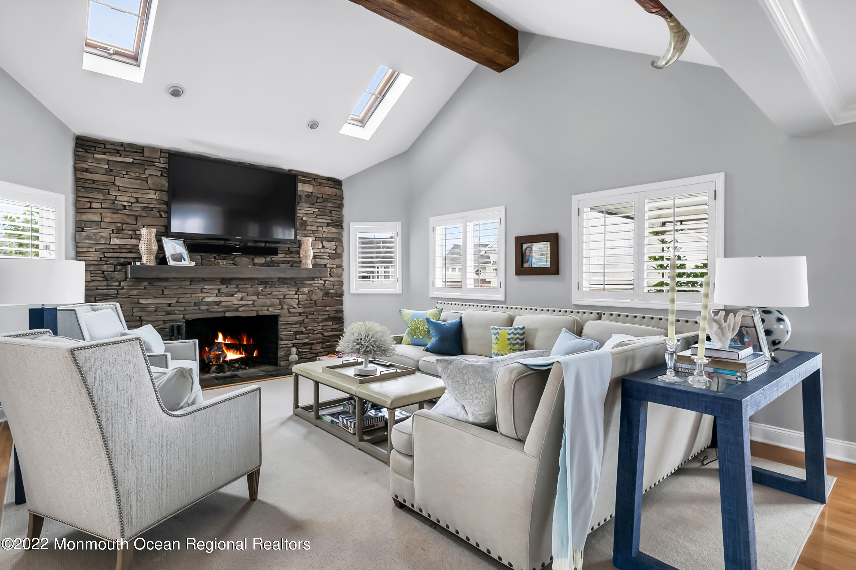 12 Captains Court Manasquan, NJ 08736 - Photo 7 of 30 a living room with furniture a flat screen tv and a fireplace