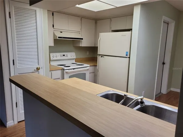 a kitchen with granite countertop a refrigerator and a sink