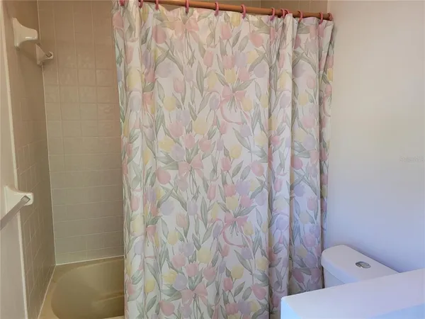 a bathroom with a toilet and shower curtain