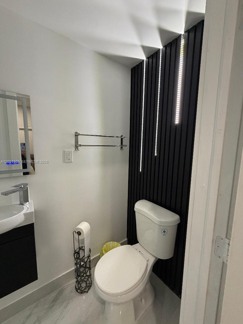 6803 Southwest 158th Avenue Miami, FL 33193 - Photo 5 of 6 a white toilet sitting next to a bathroom sink