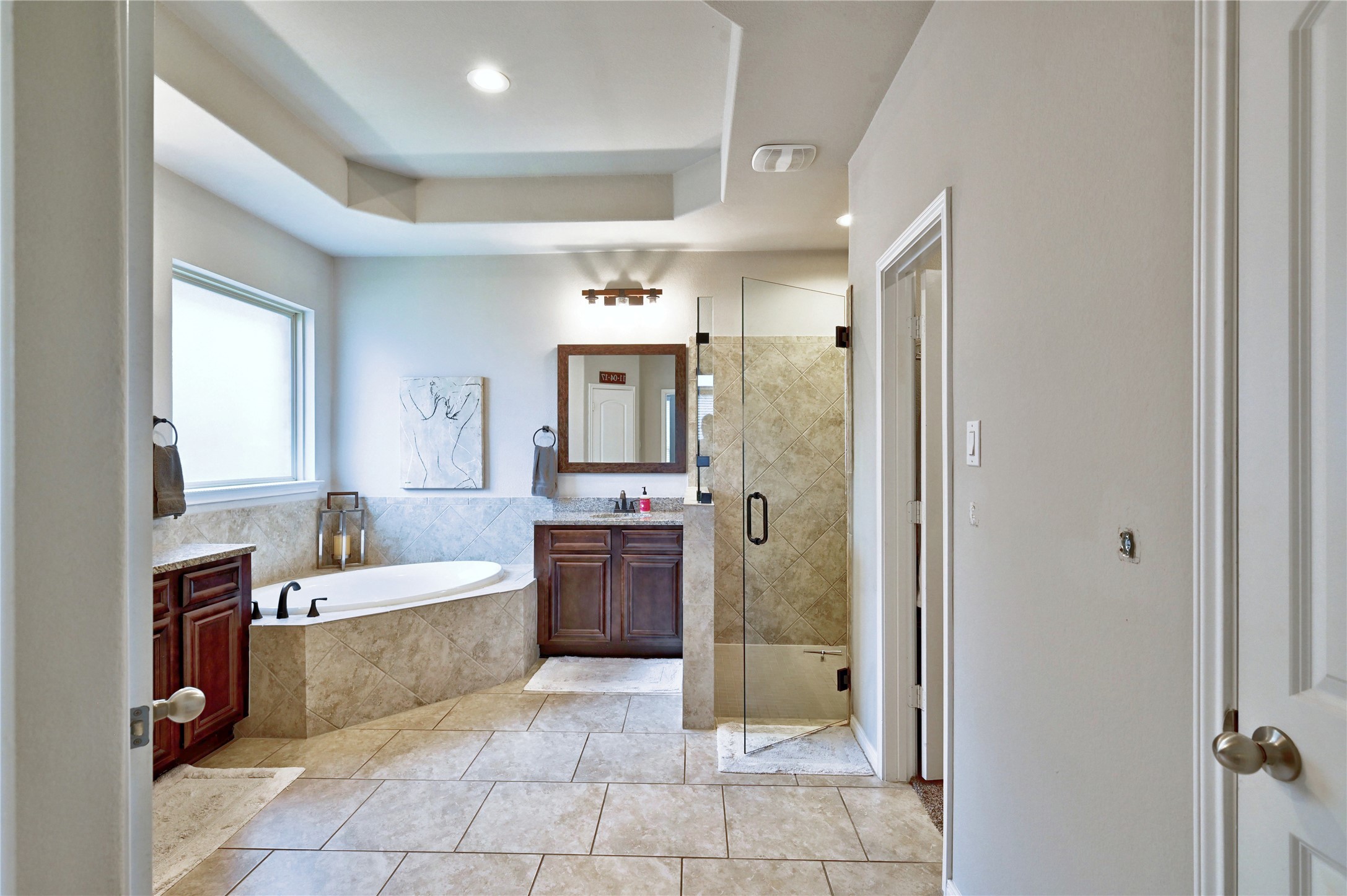 23118 Southern Brk Trail Spring, TX 77389 - Photo 27 of 50 The primary bath has recently updated faucets, showerhead, light fixtures and glass surround on the shower. There are two separate vanities and a corner tub.