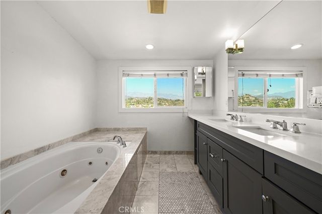 a bathroom with a tub sink and mirror