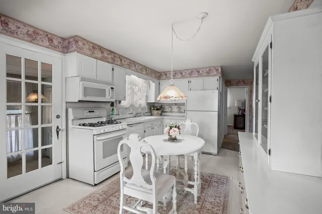 a kitchen with stainless steel appliances a refrigerator a stove a sink and white cabinets