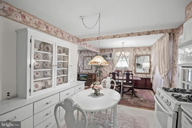 a dining room with furniture a chandelier and window