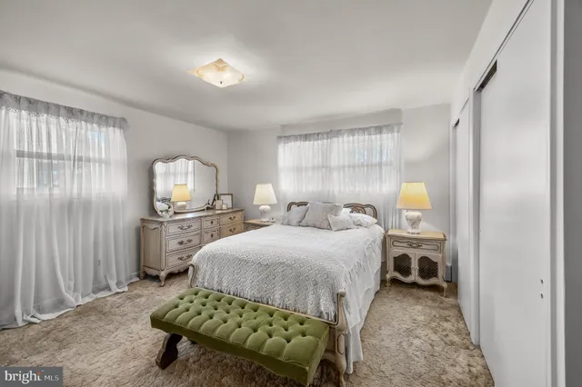 a bedroom with a bed and large windows