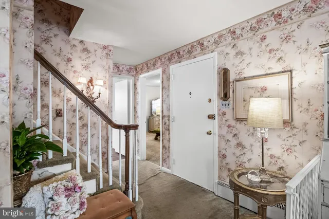 a view of a hallway with wooden floor and stairs
