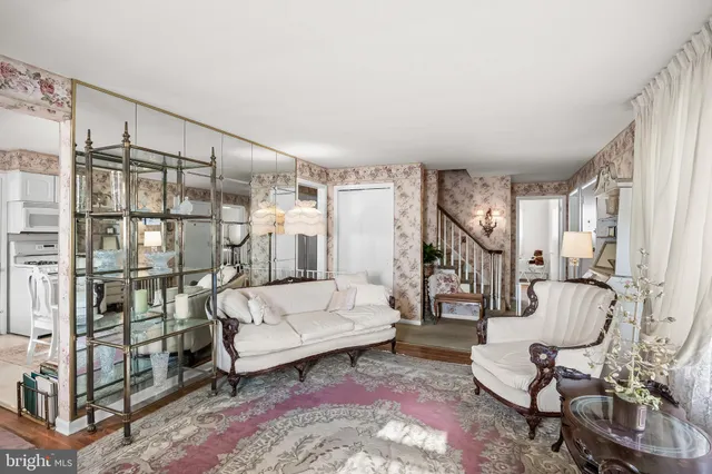 a living room with furniture a rug and white walls