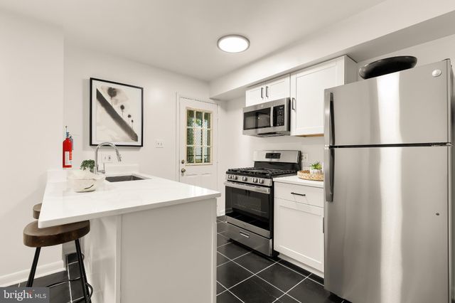 a kitchen with a sink stainless steel appliances and refrigerator