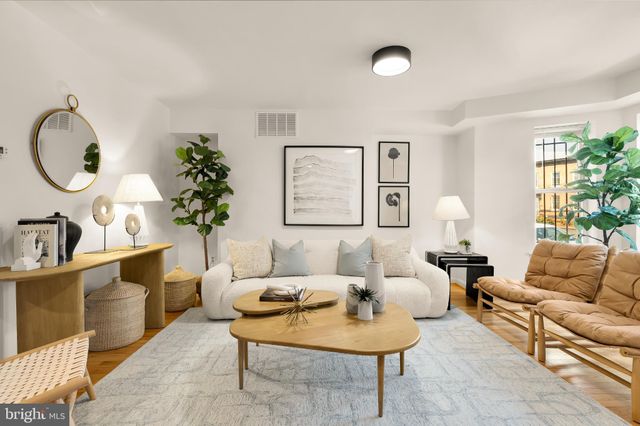 a living room with furniture a table and a potted plant