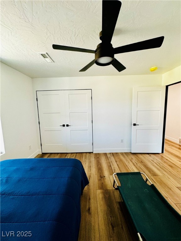 8946 Highway 93 Caliente, NV 89008 - Photo 35 of 40 Bedroom with a closet, a textured ceiling, light wood-type flooring, and a ceiling fan