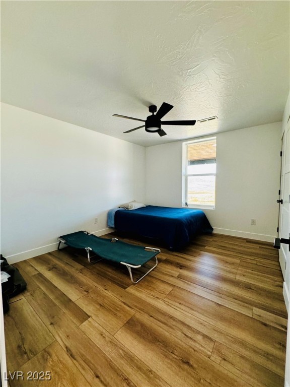 8946 Highway 93 Caliente, NV 89008 - Photo 36 of 40 Bedroom featuring wood finished floors, ceiling fan, and a textured ceiling