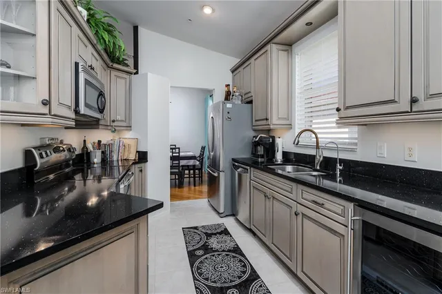 a kitchen with stainless steel appliances granite countertop a sink stove and cabinets