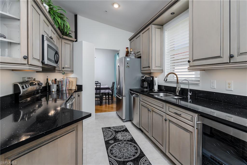 640 Lalique Circle, Unit 405 Naples, FL 34119 - Photo 11 of 49 a kitchen with stainless steel appliances granite countertop a sink stove and cabinets