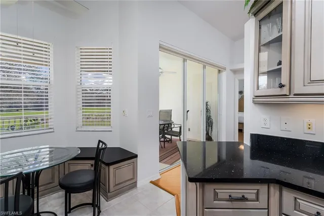 a living room with granite countertop furniture a sink a flat screen computer and a window
