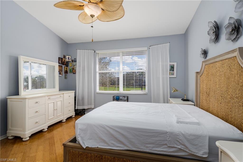 640 Lalique Circle, Unit 405 Naples, FL 34119 - Photo 19 of 49 a spacious bedroom with a bed and a dresser