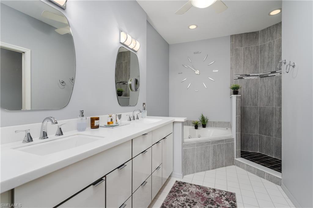 640 Lalique Circle, Unit 405 Naples, FL 34119 - Photo 21 of 49 a bathroom with a double vanity sink mirror and shower