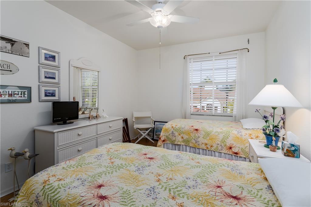 640 Lalique Circle, Unit 405 Naples, FL 34119 - Photo 28 of 49 a bedroom with a bed and a flat screen tv