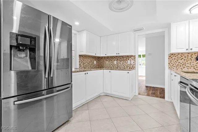 a kitchen with white cabinets and stainless steel appliances