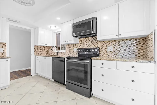 a kitchen with white cabinets stainless steel appliances and sink