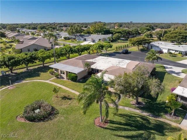 an aerial view of residential houses with outdoor space and trees