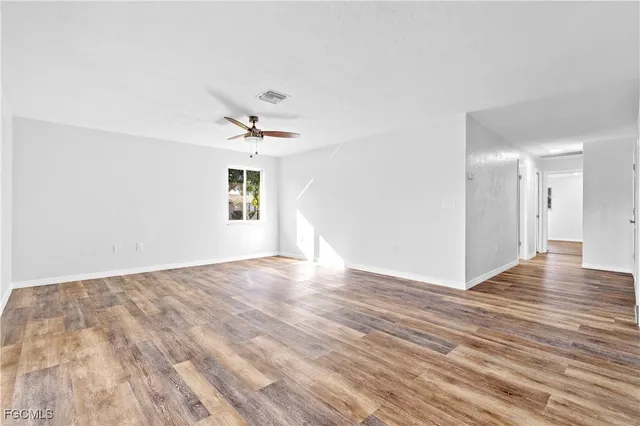 a view of a room with wooden floor and a ceiling fan