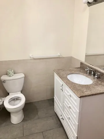 a bathroom with a granite countertop toilet and sink