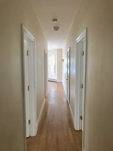 a view of a small space with wooden floor and a window