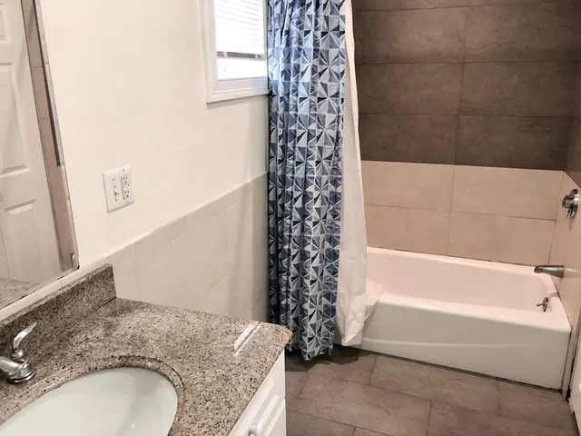 a bathroom with a granite countertop toilet a sink and a mirror