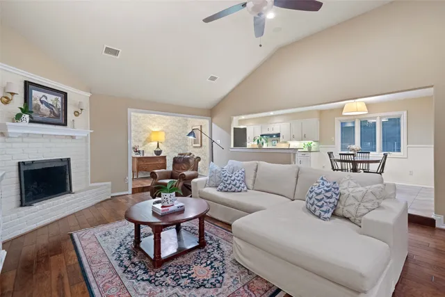 a living room with furniture a fireplace a rug and a chandelier