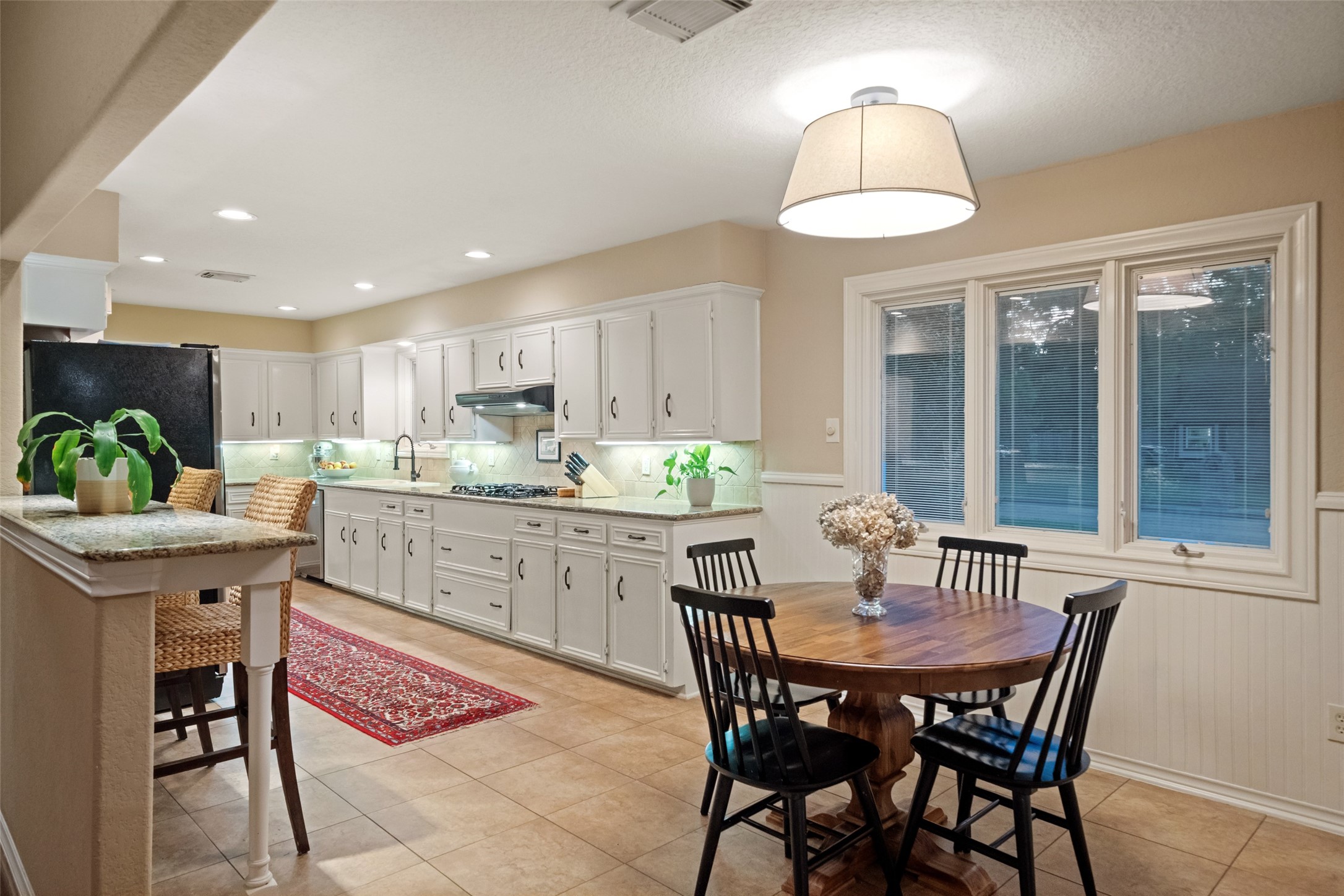 722 Shadow Brook Drive Spring, TX 77380 - Photo 17 of 27 a kitchen with a dining table chairs and white cabinets
