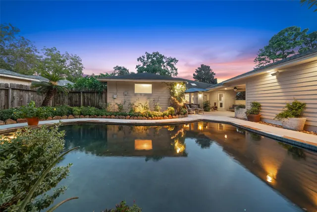 a view of swimming pool with outdoor seating and plants