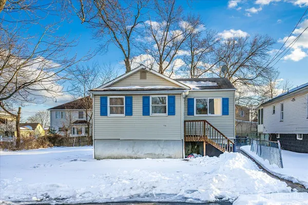 a front view of a house with a yard covered with snow
