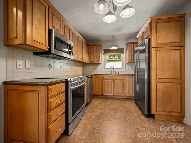 a kitchen with stainless steel appliances granite countertop a refrigerator stove microwave and sink