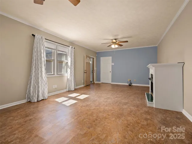 an empty room with windows and ceiling fan