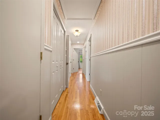 a view of a hallway with wooden floor and staircase